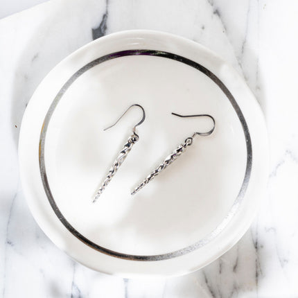 pewter icicle earrings in a white and silver catchall dish