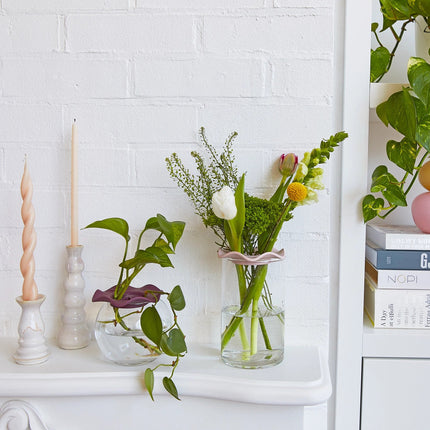 a white room with two vases filled with flowers using the botanical keepers to aid in the flower arrangement on a white mantle