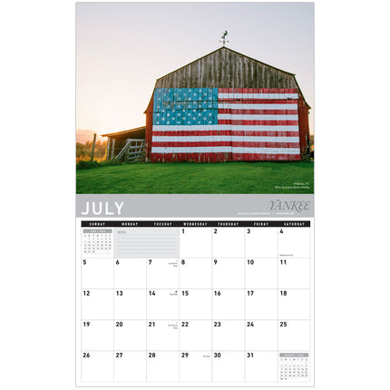 Calendar page for July showing a barn with an American flag design.