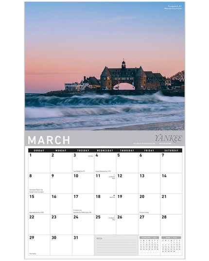 Calendar with March 2023 dates and a scenic image of a building by the sea.