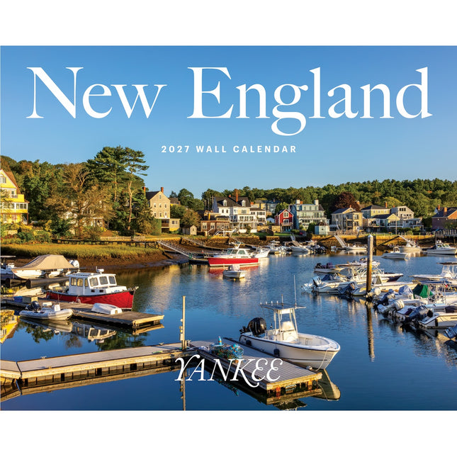New England 2027 wall calendar cover featuring a scenic harbor with boats, docks, and coastal houses under a blue sky, with large white 'New England' text at the top and 'YANKEE' near the bottom.
