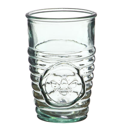 a clear drinking glass with ribbed texture on the lower half with a circular emblem of a bee