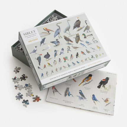 Bird-themed puzzle set with pieces scattered on a white background