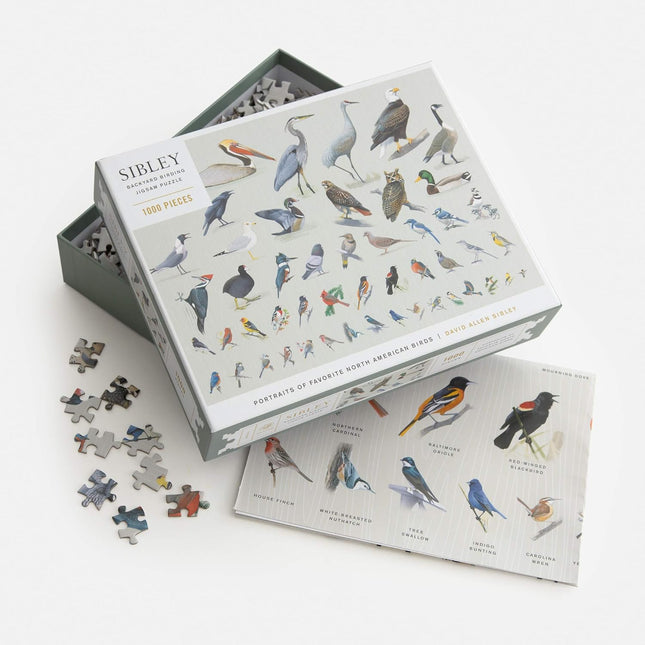 Bird-themed puzzle set with pieces scattered on a white background