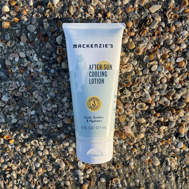 a bottle of after sun cooling lotion on a pebbled beach