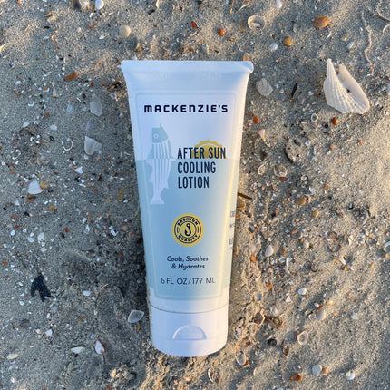 a bottle of after sun cooling lotion on a sandy beach