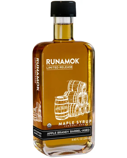 Bottle of Runamok maple syrup with barrels on a white background