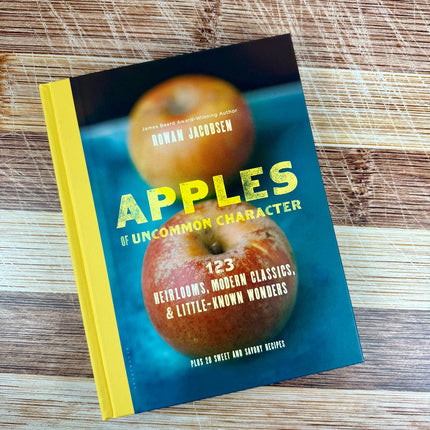 Book titled 'Apples of Uncommon Character' on a wooden surface