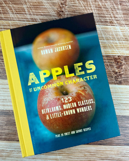Book titled 'Apples of Uncommon Character' on a wooden surface