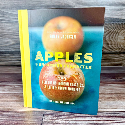 Book titled 'Apples of Uncommon Character' with images of apples on a wooden surface