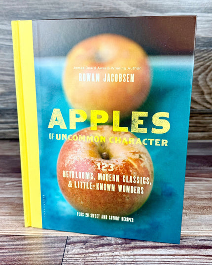 Book titled 'Apples of Uncommon Character' with images of apples on a wooden surface