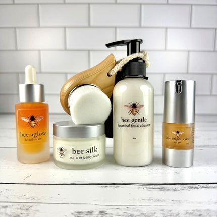 Collection of skincare products with bee-themed packaging on a white surface.