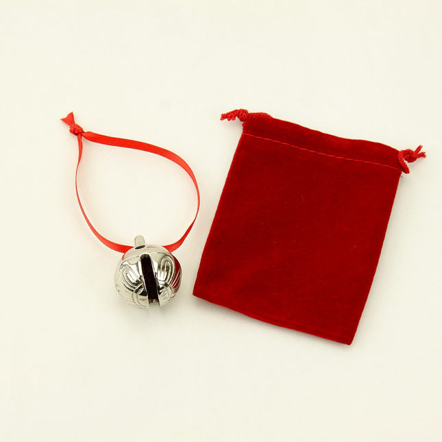 Silver bell with red string and red velvet pouch on a white background