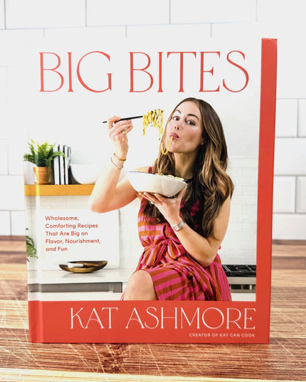 Book cover of 'Big Bites' by Kat Ashmore with a woman eating noodles.