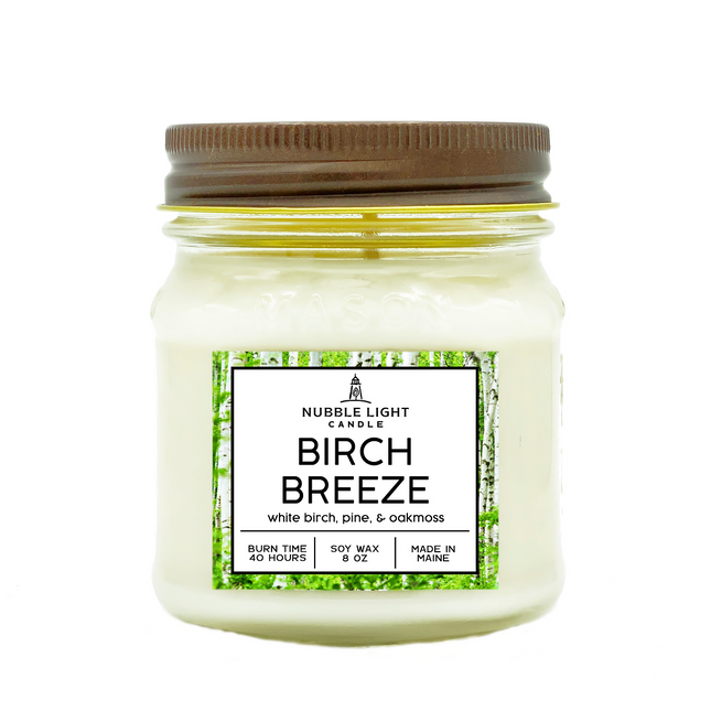 Jar candle labeled 'Birch Breeze' with a brown lid on a white background