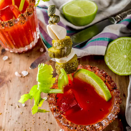  Bloody Mary cocktail with garnishes on a wooden surface