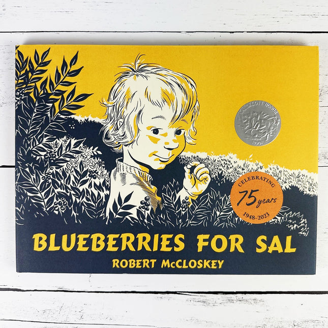 Book cover of 'Blueberries for Sal' by Robert McCloskey with a child illustration on a yellow and black background.