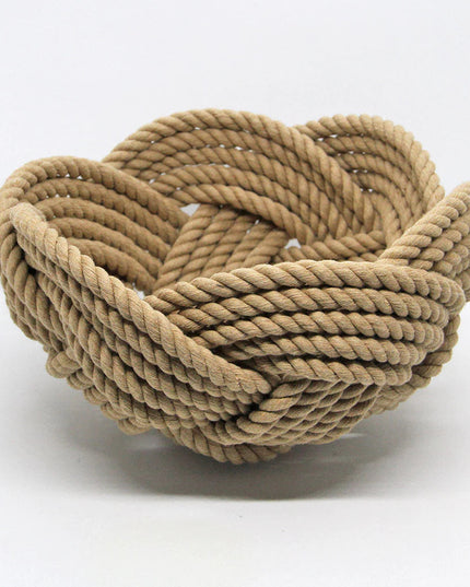 a hand woven cotton rope bowl in tan against a white background