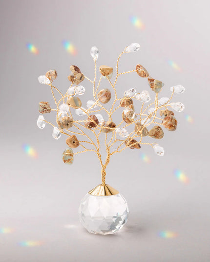 Decorative tree with gold branches and crystal base adorned with aqua terra stones and clear crystals casting tiny rainbows against the light gray background