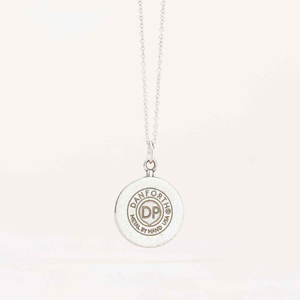 Back view of the Crescent Moon Necklace displaying the maker's mark stamped on the pewter, indicating the handcrafted quality of the piece