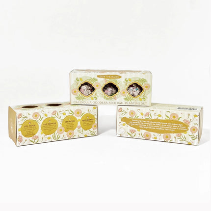 a pyramid stack of 3 boxes of calendula seed ball gift sets, each box facing to show a different side of the package