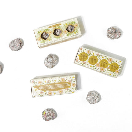 a trio of seed ball sets on a white background with seed balls scattered about them