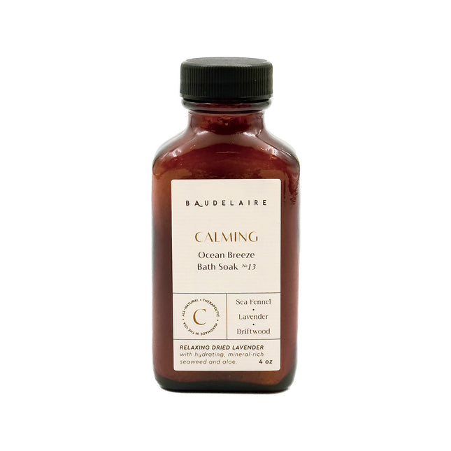 an amber colored apothecary style bottle with a black cap and off white label that reads "Baudelaire - Calming - Ocean Breeze Soak no. 13 - Sea Fennel - Lavender - Driftwood"