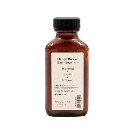 an amber colored apothecary style bottle with a black cap and off white label that reads "Ocean Breeze Soak no. 13 - Sea Fennel - Lavender - Driftwood" with an ingredients list and business address