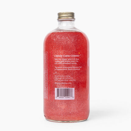 Bottle with red glittery liquid and gold cap on a white background