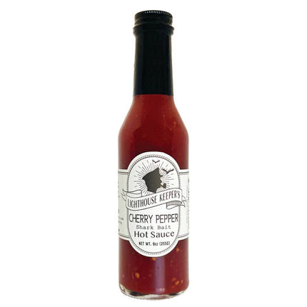 a tall slender bottle of cherry pepper hot sauce