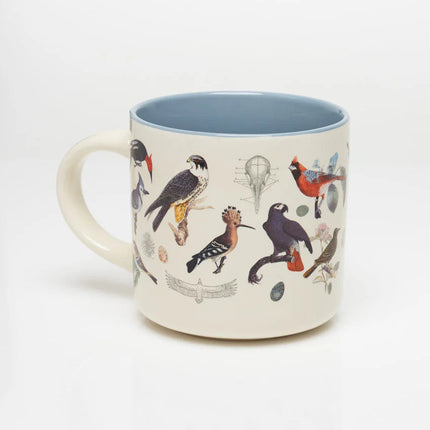 a white coffee mug with vintage illustrations of birds wrapping around it, and a solid sky blue print on the inside of the mug