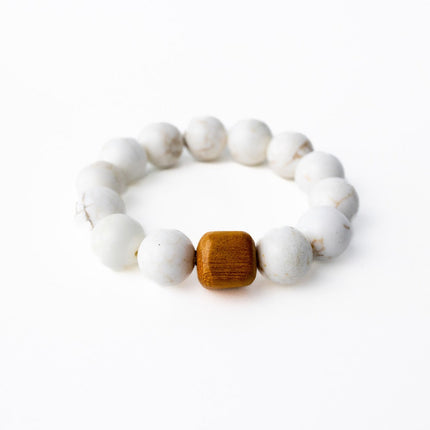 White beaded bracelet with a wooden bead on a white background