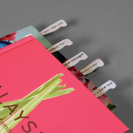 Colorful cookbooks with knife page markers sticking out of the top of the pages