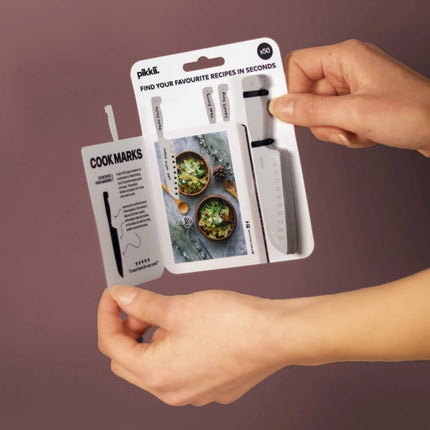 Pikkii cook marks packaging held by hands against a purple background