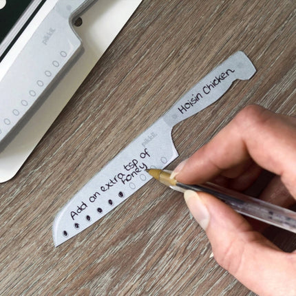 Hand writing on a label with a pen on a wooden surface