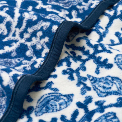 Close-up of blue and white coral and shell patterned blanket