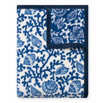 Folded blanket with blue and white marine pattern on a white background