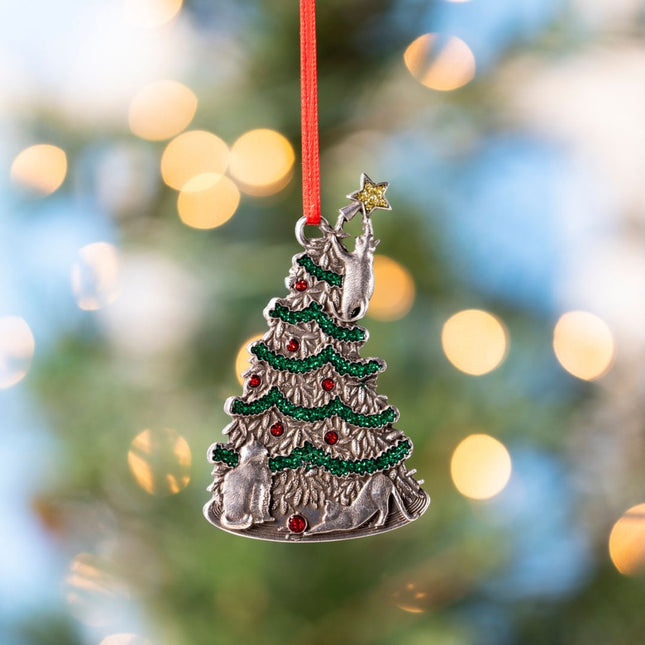 Decorative Christmas tree ornament with red ribbon against a blurred festive background