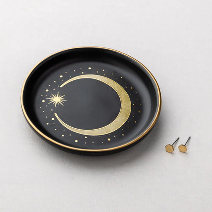 Black plate with gold crescent moon design on a light gray background