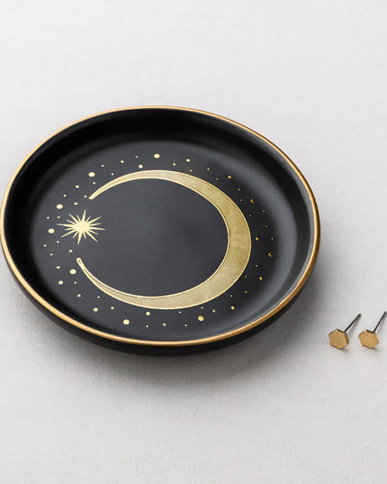 Black plate with gold crescent moon design on a light gray background