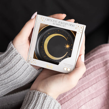 Person holding a box of a crescent jewelry dish packaging set.