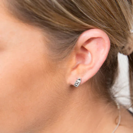 Close-up of an ear wearing a small earring with a blurred background