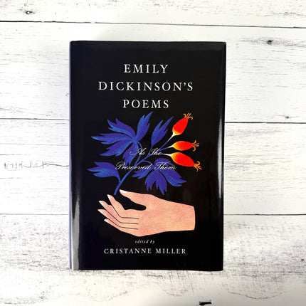 Book titled 'Emily Dickinson's Poems As She Preserved Them' on a white wooden surface