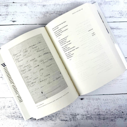 Open book on a wooden surface with handwritten text
