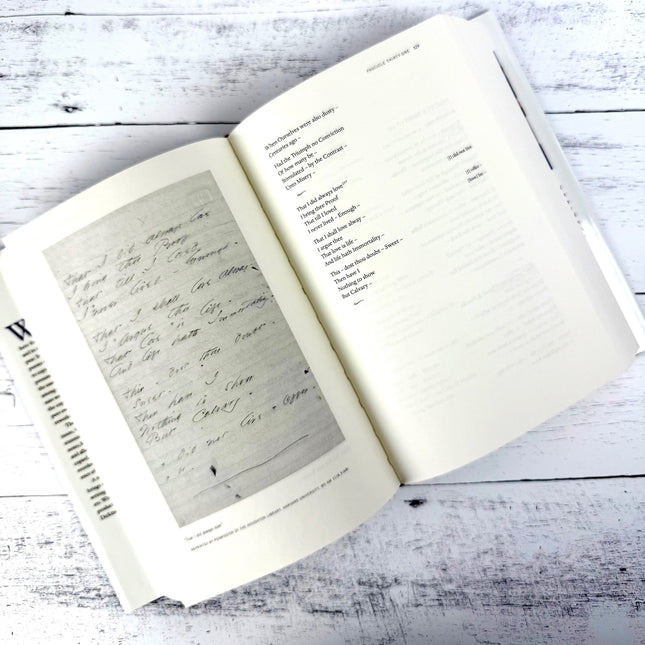 Open book on a wooden surface with handwritten text