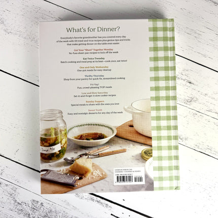Book cover with a checkered pattern and cooking-themed imagery on a wooden surface