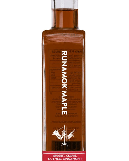 A side view of a bottle of festivus infused maple syrup against a white background