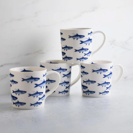 Set of four mugs with blue fish pattern on a light gray surface