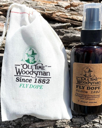 a bottle of ole time woodsman fly dope on a log