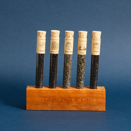 Set of tea samples in wooden holder with cork lids on a blue background
